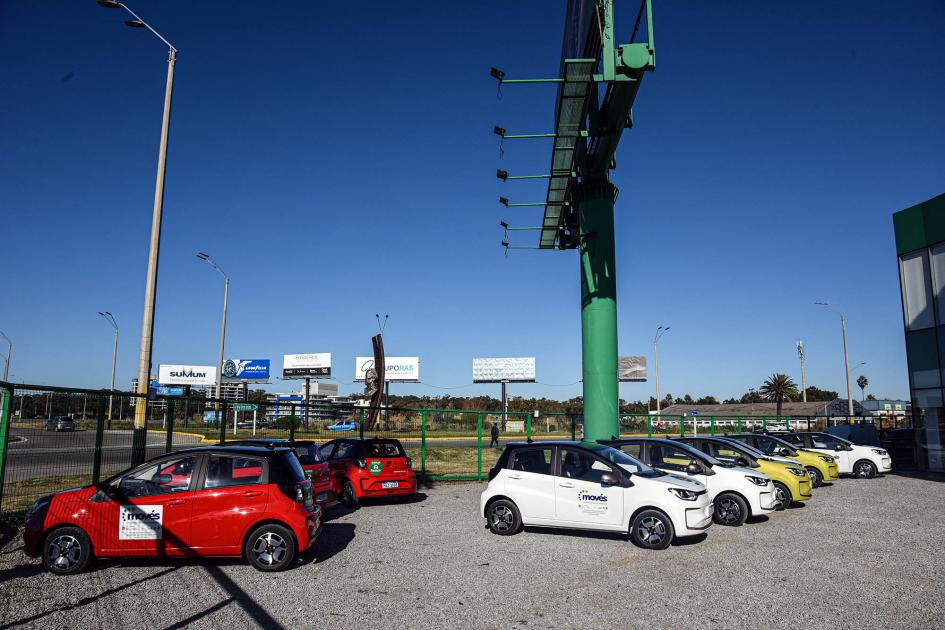 Autos blancos, rojos y amarillos limón en el estacionamiento de Europcar; el día está claro