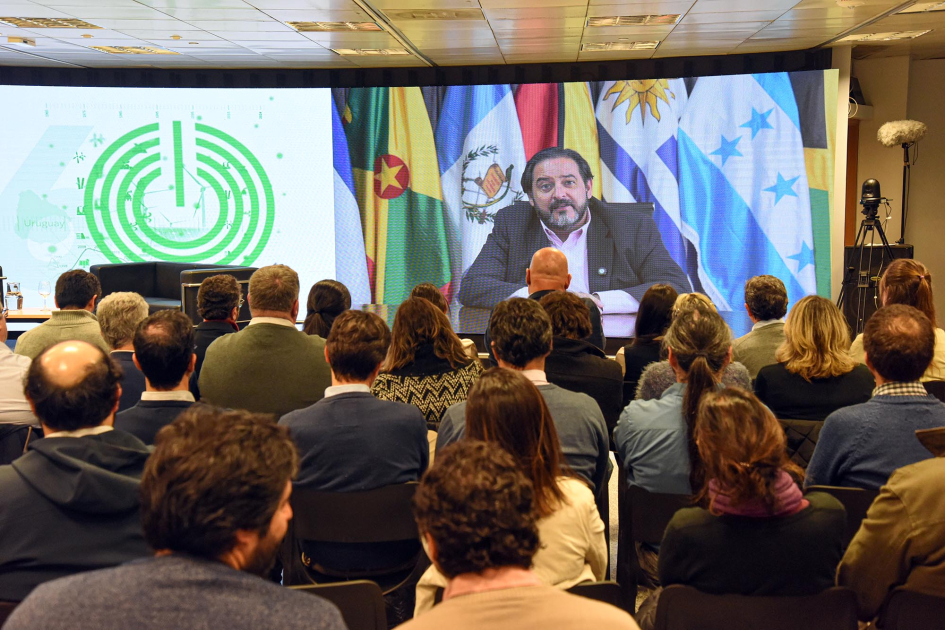 El secretario ejecutivo de OLADE, Andrés Rebolledo, envió un mensaje sobre la importancia del BEN Público, sentado; al fondo, pantalla con video de Rebolledo