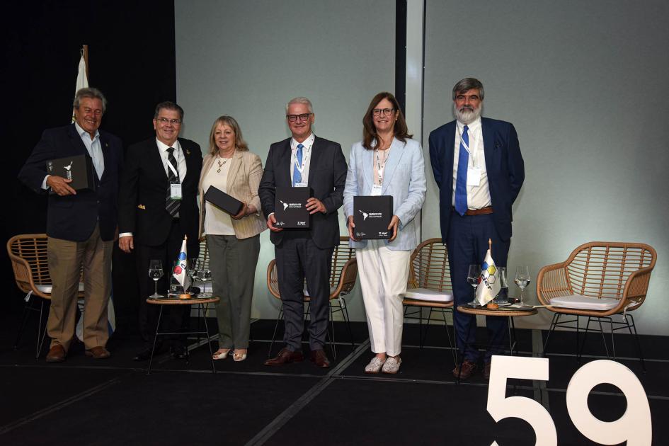 Entrega de reconocimientos en la apertura del evento Panelistas, de pie, junto a invitados especiales; sostienen cajas