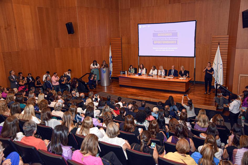 Auditorio; debajo, mesa de autoridades y pantalla