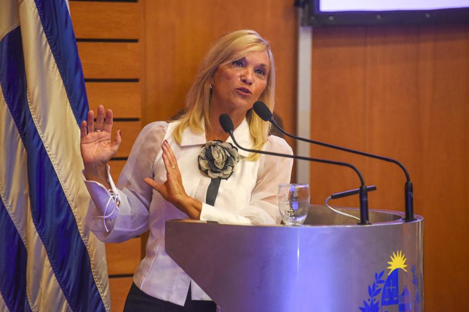 Vicepresidenta Argimón habla desde un atril; detrás, la bandera uruguaya