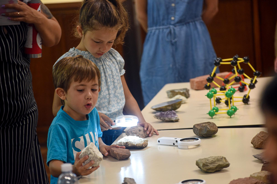 Actividad en el Museo Geominero Niña y niño, junto a una mesa con piedras