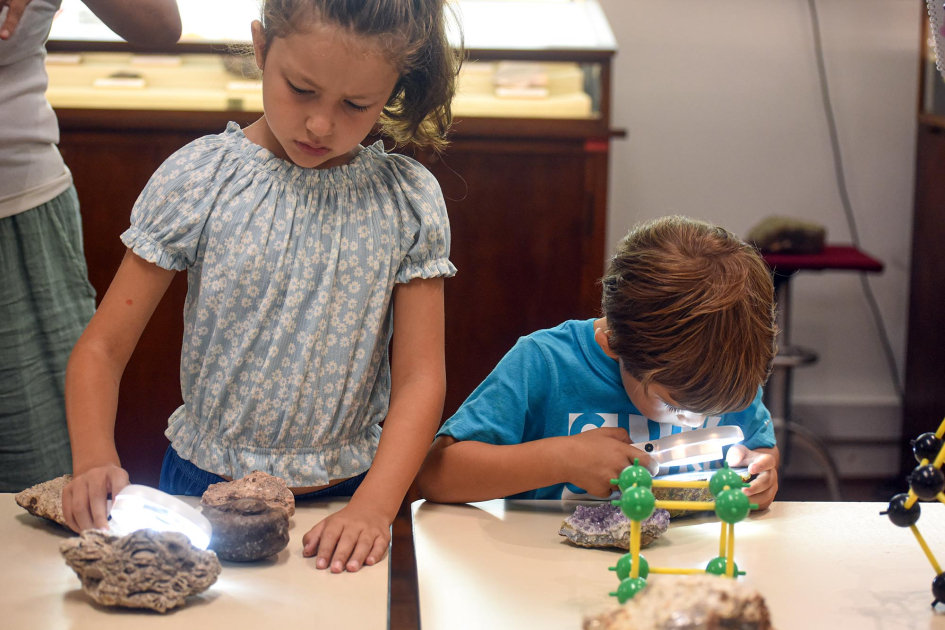 Actividad en el Museo Geominero Niña y niño observan piedras