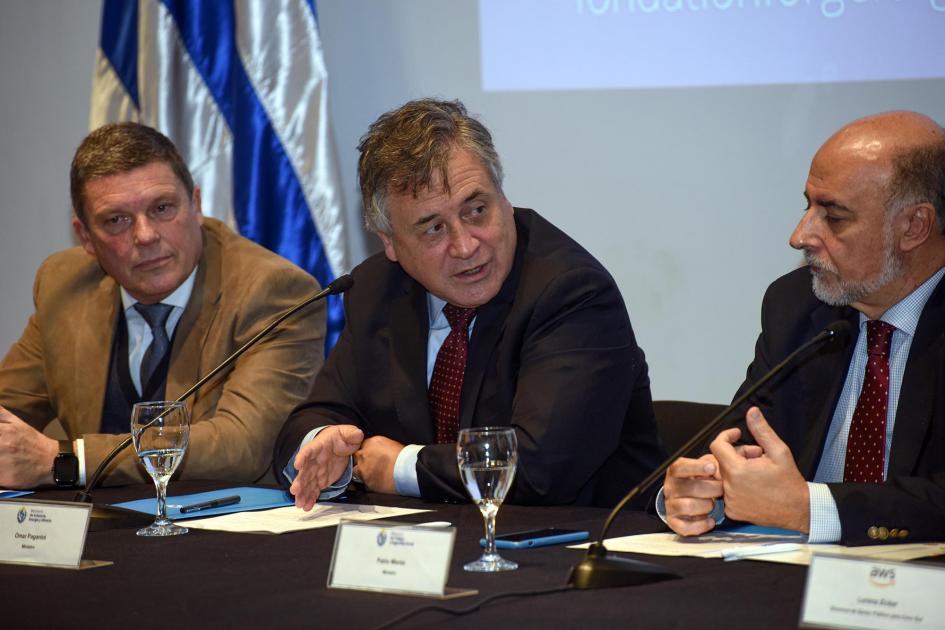 El ministro Omar Paganini expuso en la apertura Habla el ministro Omar Paganini junto a Mieres y Darscht; detrás hay una bandera uruguaya