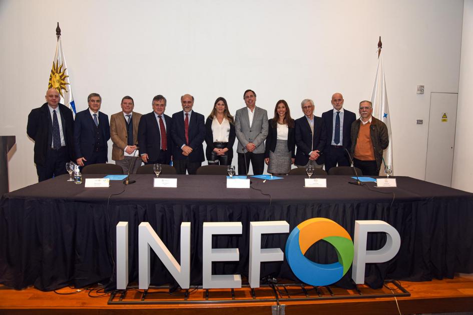 Autoridades posan para la foto detrás de la mesa, que tiene un cartel de Inefop