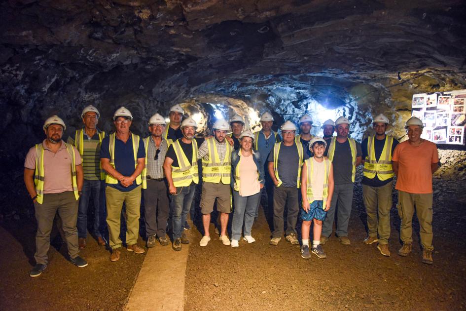 Director de Dinamige, Marcelo Pugliesi, junto a miembros de la Asociación de Mineros de Artigas Diecisiete personas, de pie, en el interior de una mina