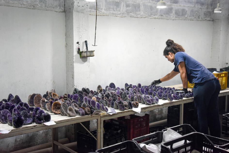 Mujer trabajadora del sector minero, en Artigas Mujer trabaja en una mesa con muchas piedras