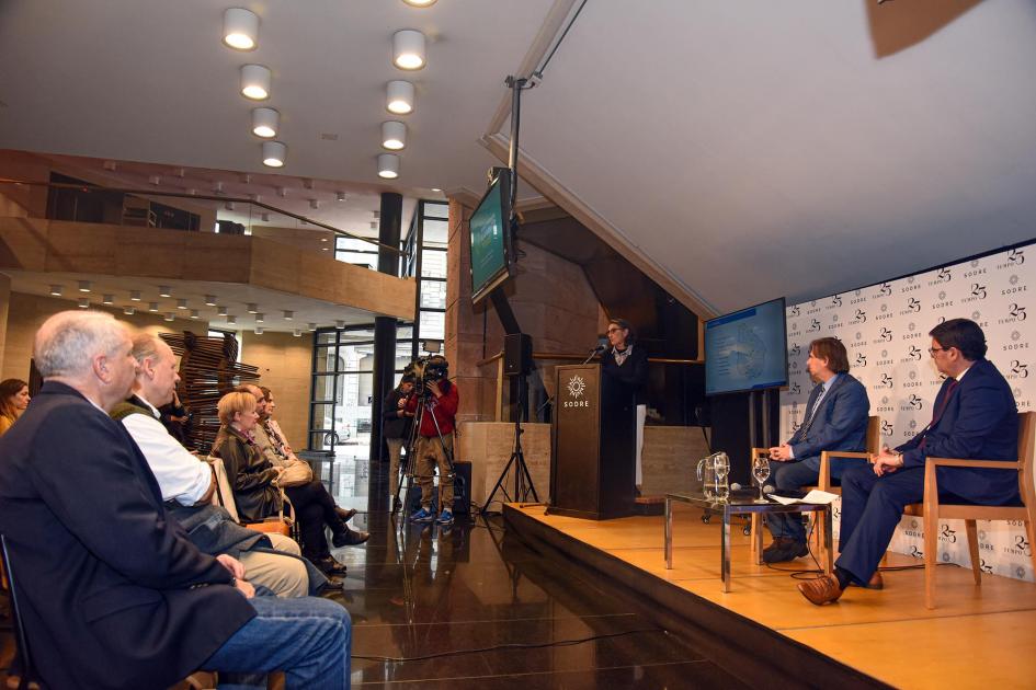 La arquitecta del MIEM Alicia Mimbacas hizo un resumen del trabajo realizado en 2021 y 2022 A la izquierda, público; a la derecha, las autoridades en un escenario; en un atril habla una mujer