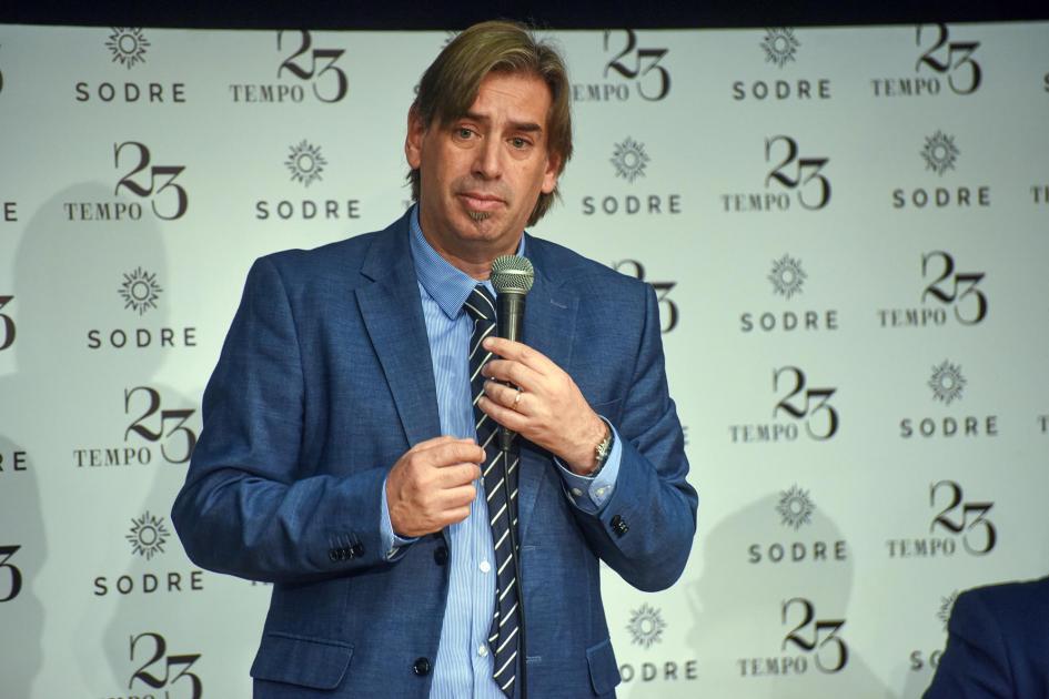 Presidente de MEVIR, Juan Pablo Delgado Delgado habla con un micrófono; detrás, banner de MEVIR