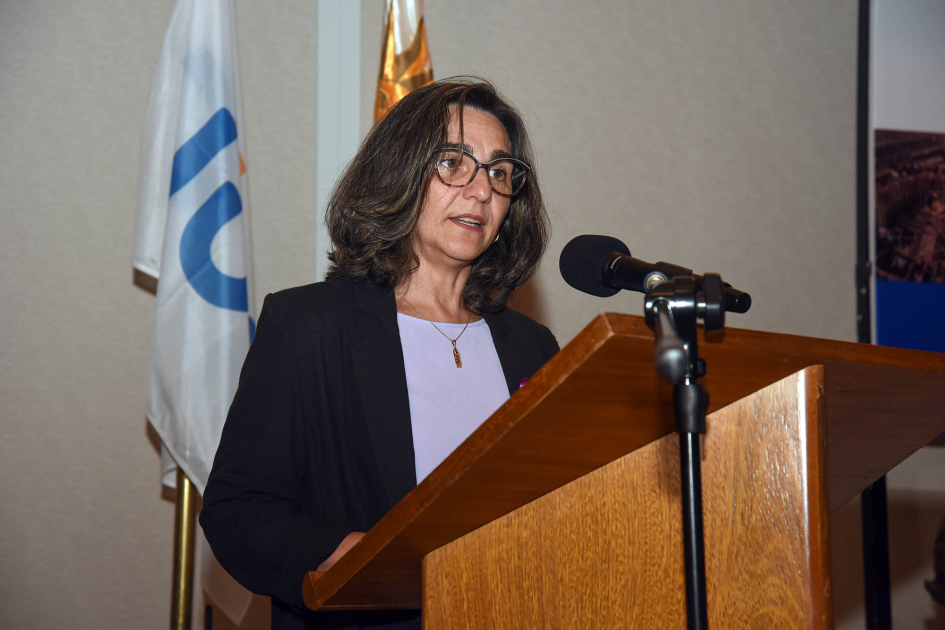 Presidenta de UTE, Andrea Cabrera Cabrera habla desde un atril; detrás, banderas de Uruguay y de UE