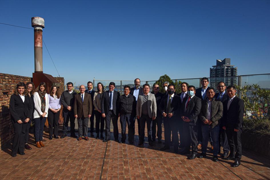 Delegaciones reunidas Foto de todos los participantes en una terraza; a la izquierda se ve una chimenea; es un día de sol