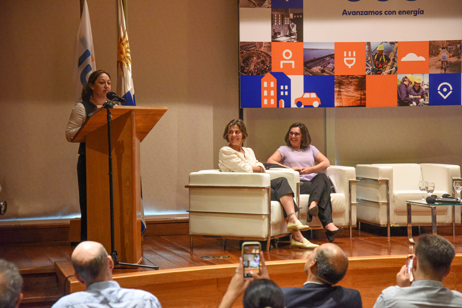 Conversatorio de UTE por el Día Internacional de la Mujer 2026 Cardona habla desde un atril; a su lado, panelistas, sentadas