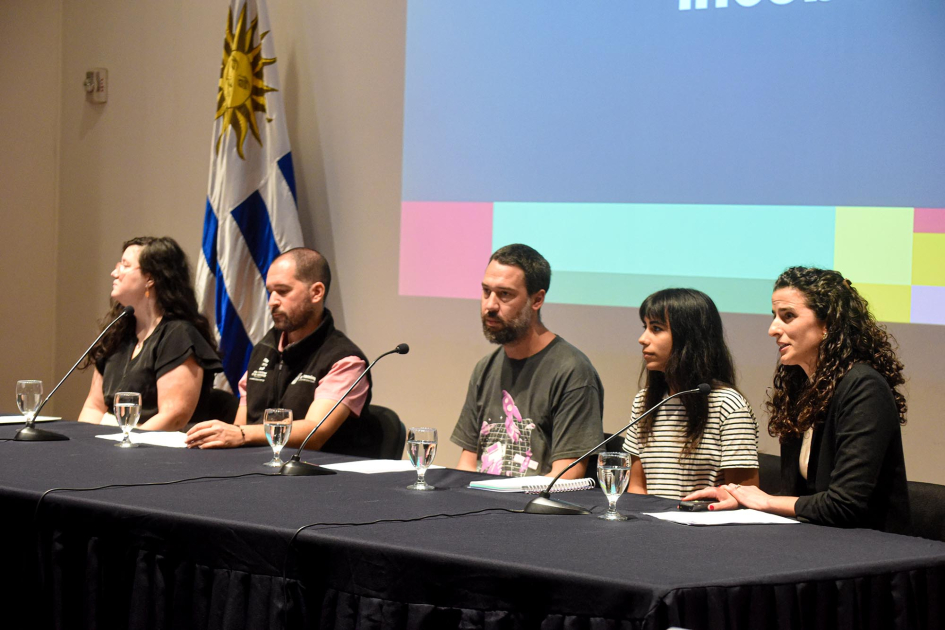 Incubadoras compartieron su experiencia Cinco mujeres y hombres, en una mesa; detrás, bandera uruguaya y pantalla