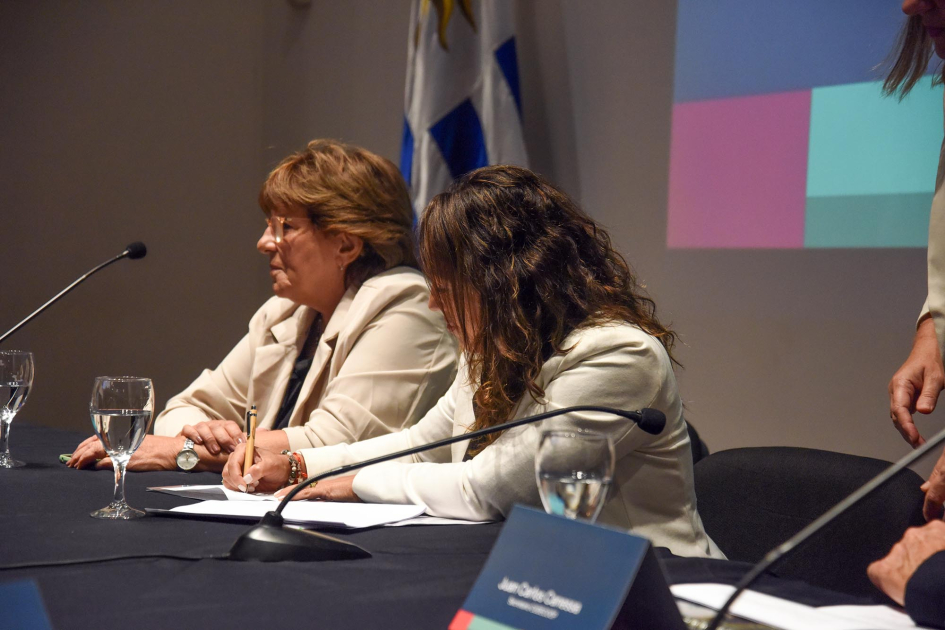 Firma de convenio 2026-2027 Cardona firma un documento, junto a Fernández