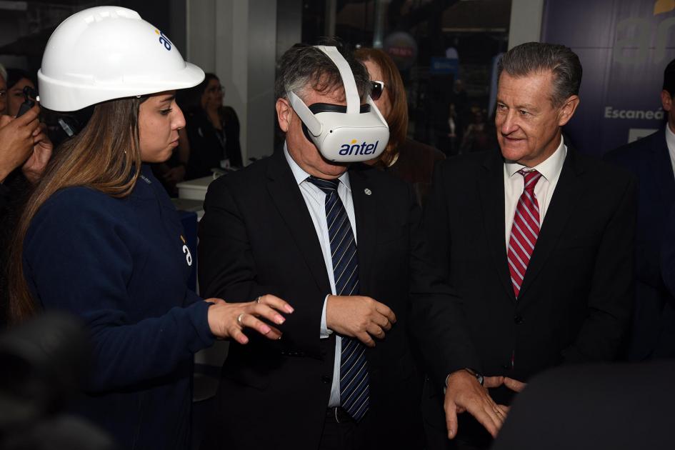 Ministro Paganini prueba lentes de realidad virtual junto al presidente de Antel y una joven