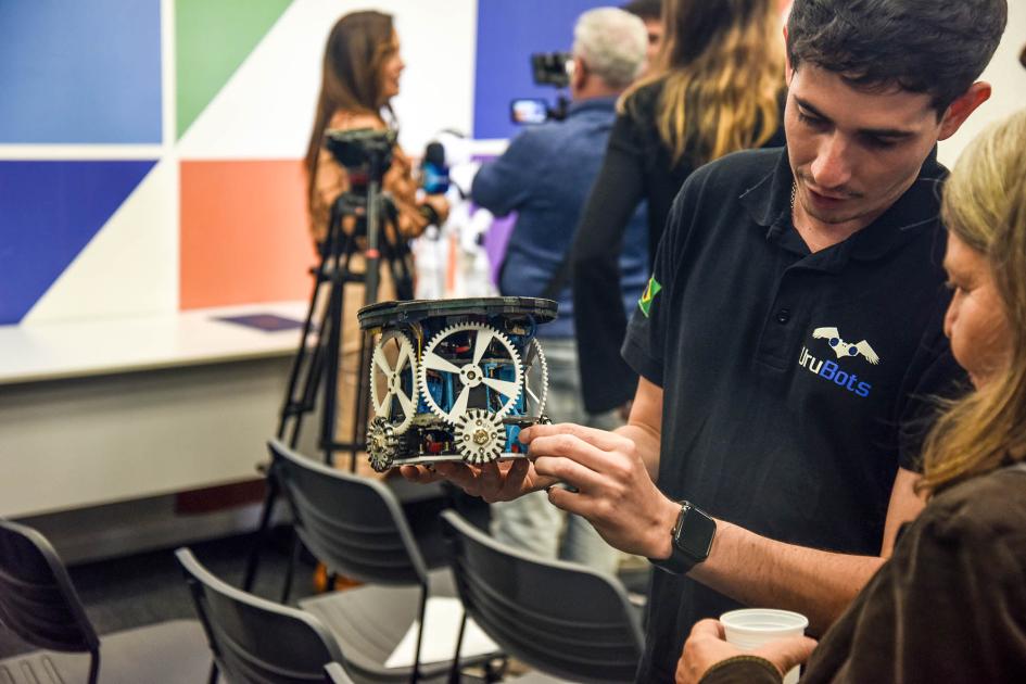 Estudiante mostrando robot Estudiante mostrando robot
