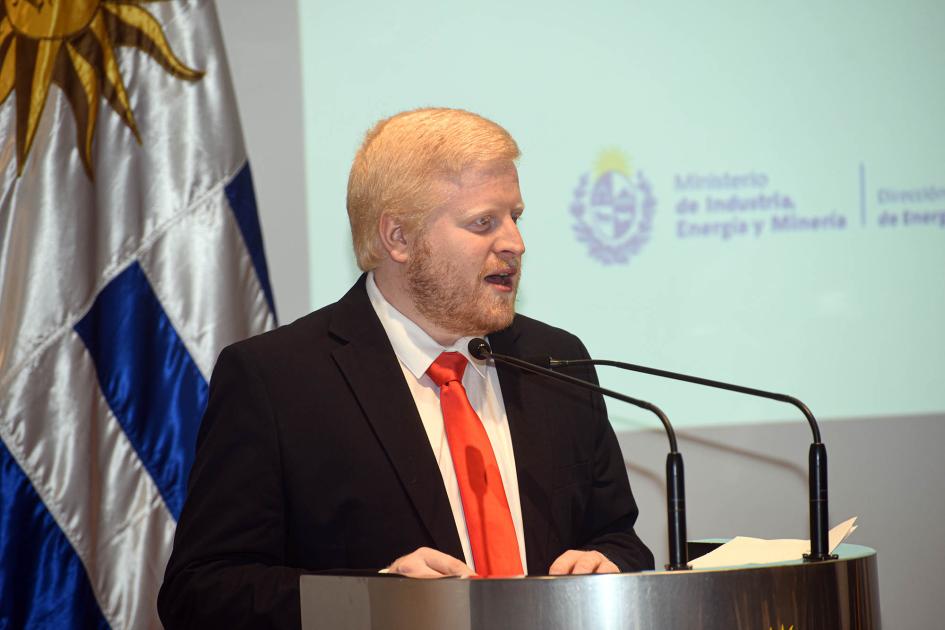 Director nacional de Energía, Christian Nieves Nieves habla desde un atril; detrás, bandera uruguaya