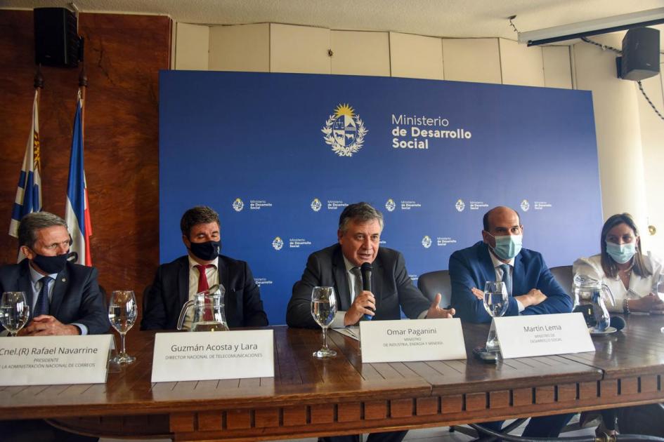 Mesa de autoridades; detrás hay un banner grande del Mides y a la izquierda los pabellones patrios