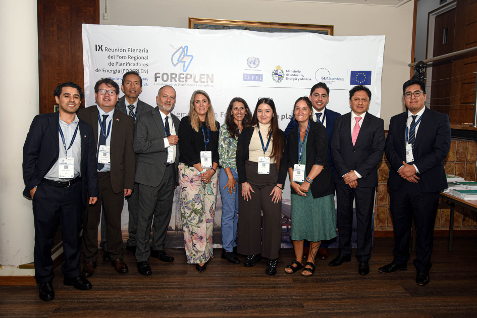 Personas de pie; detrás, banner del evento