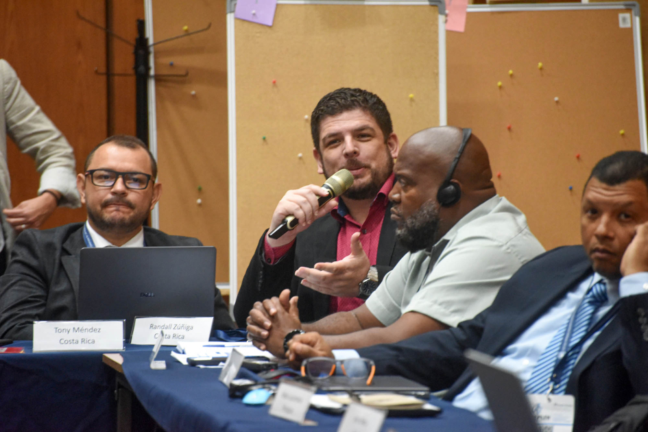 Personas sentadas en mesas que forman ángulo de 90 grados