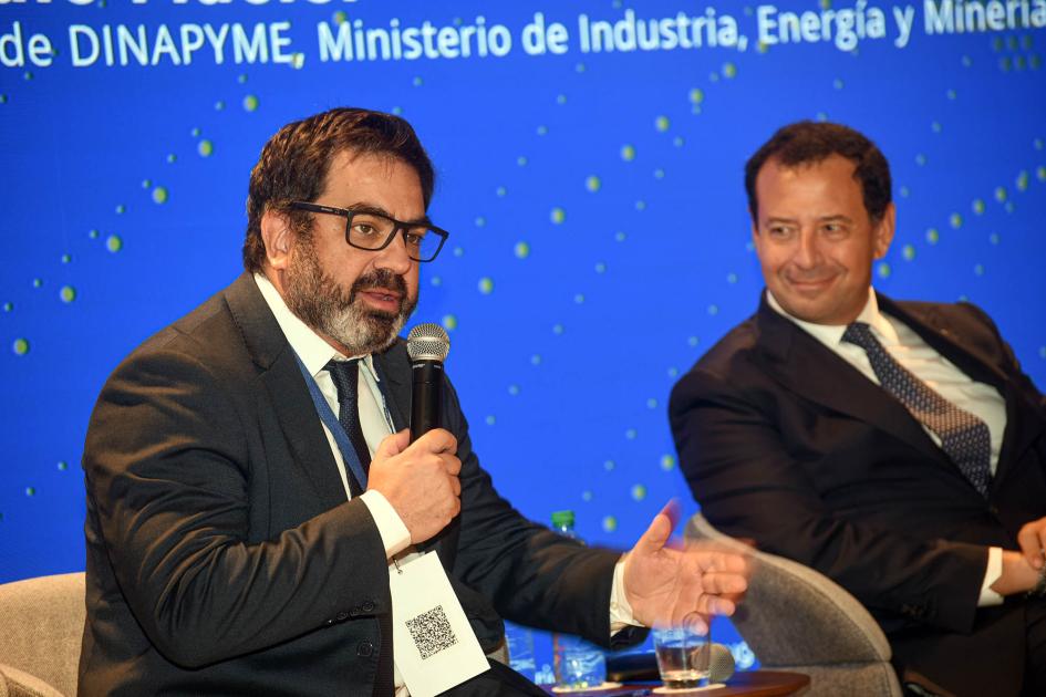 Director Gonzalo Maciel, en el cierre del evento Director Maciel habla en un sillón; a su lado, un hombre