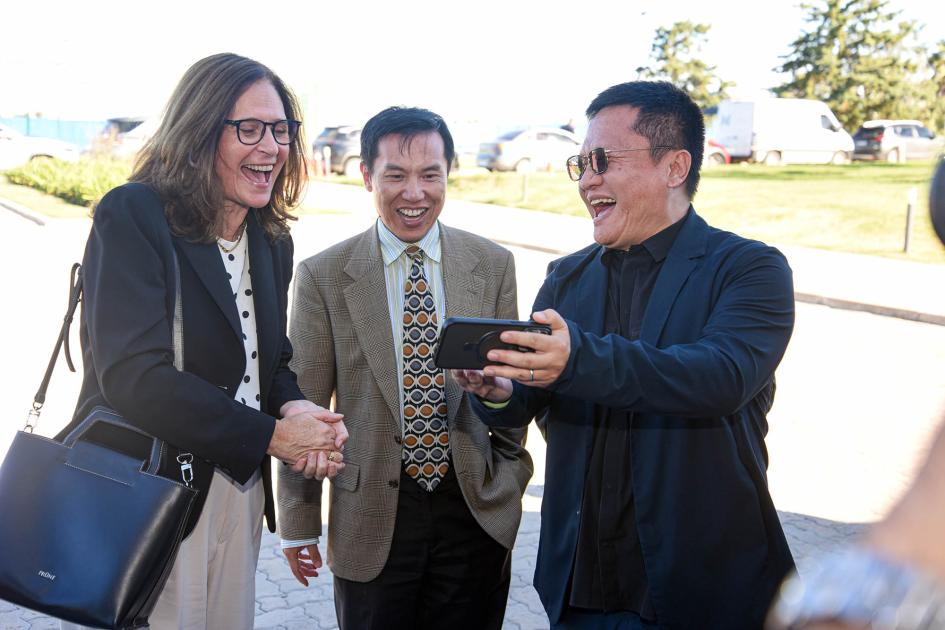 La ministra Facio dialogó con los representantes chinos en Uruguay Ministra Facio sonríe junto a dos representantes chinos, mirando un celular