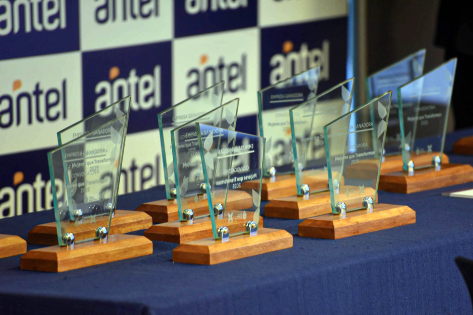 Estatuillas de vidrio y base de madera sobre mesa con mantel azul