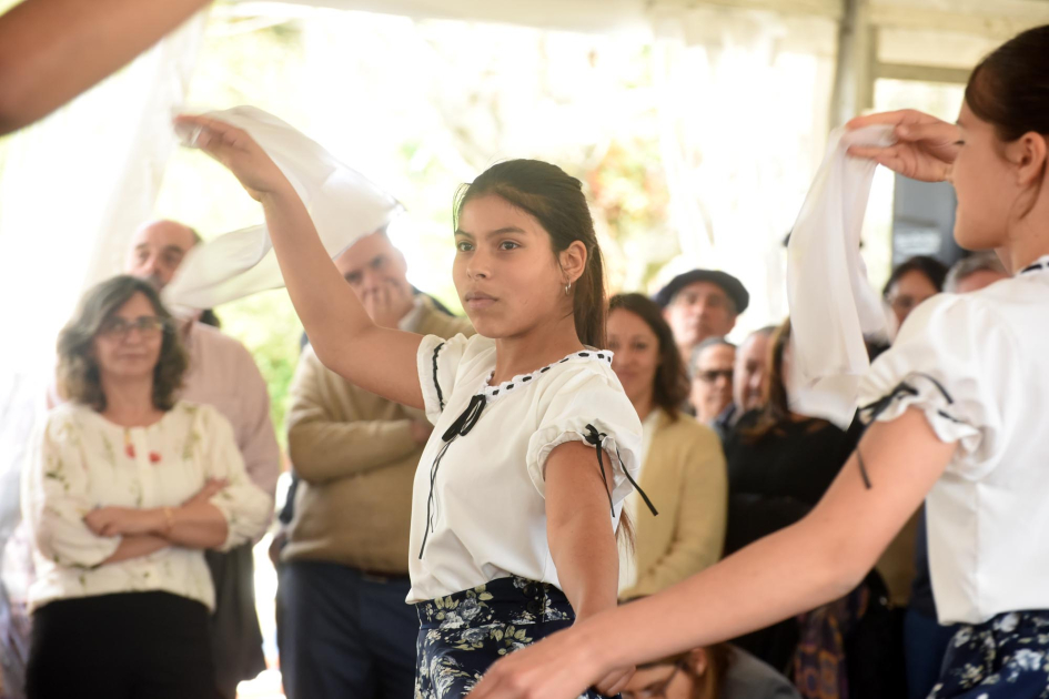 Niños y niñas bailan. Detrás, presidenta de UTE
