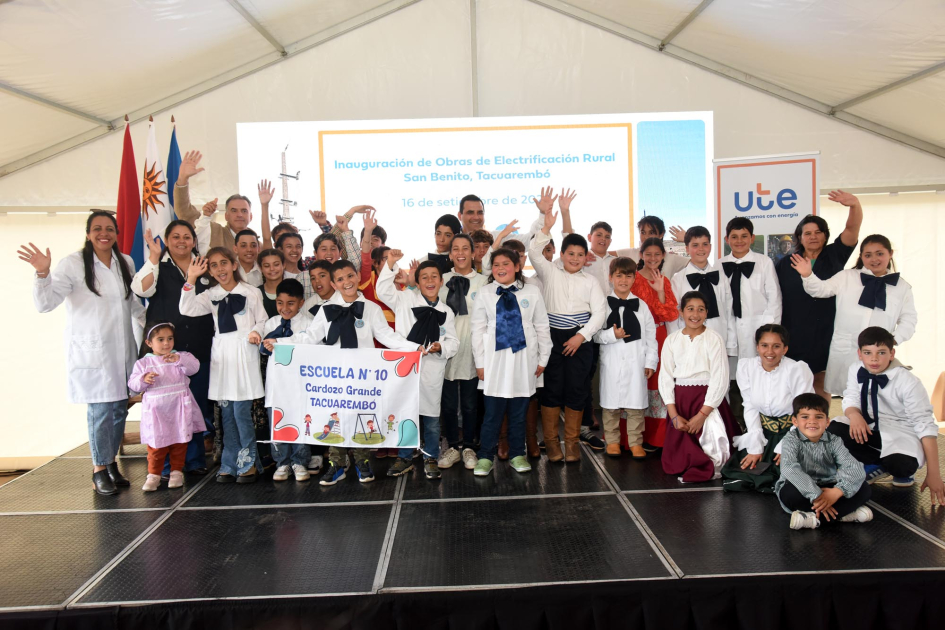 Niños de escuela con túnica blanca y moña azul 