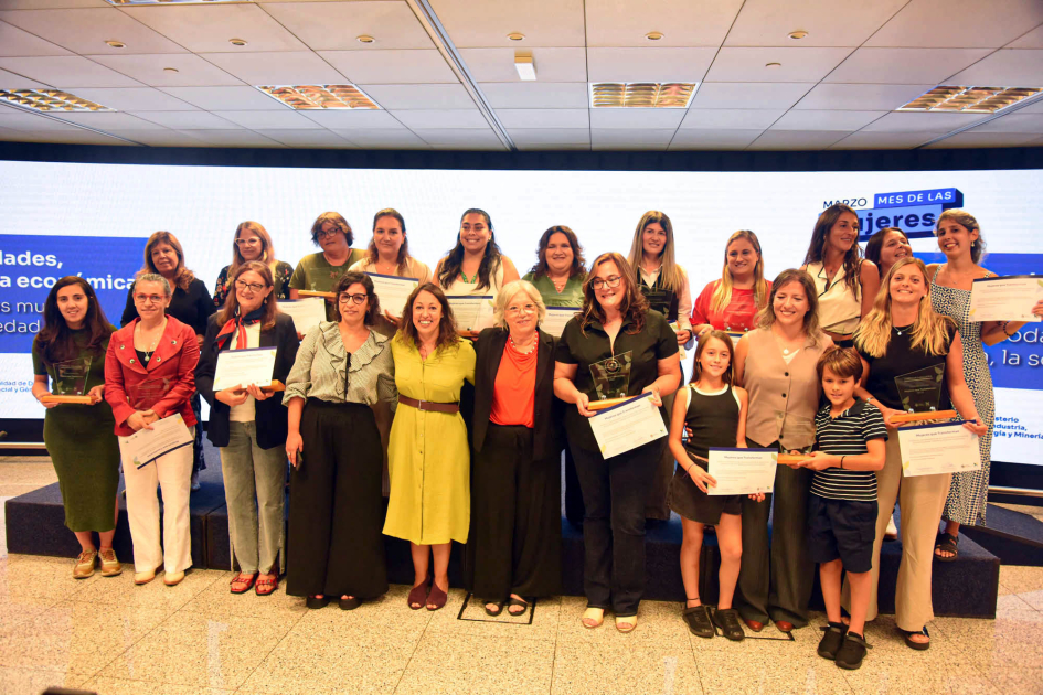 Mujeres con estatuilla y diploma posan junto a autoridades