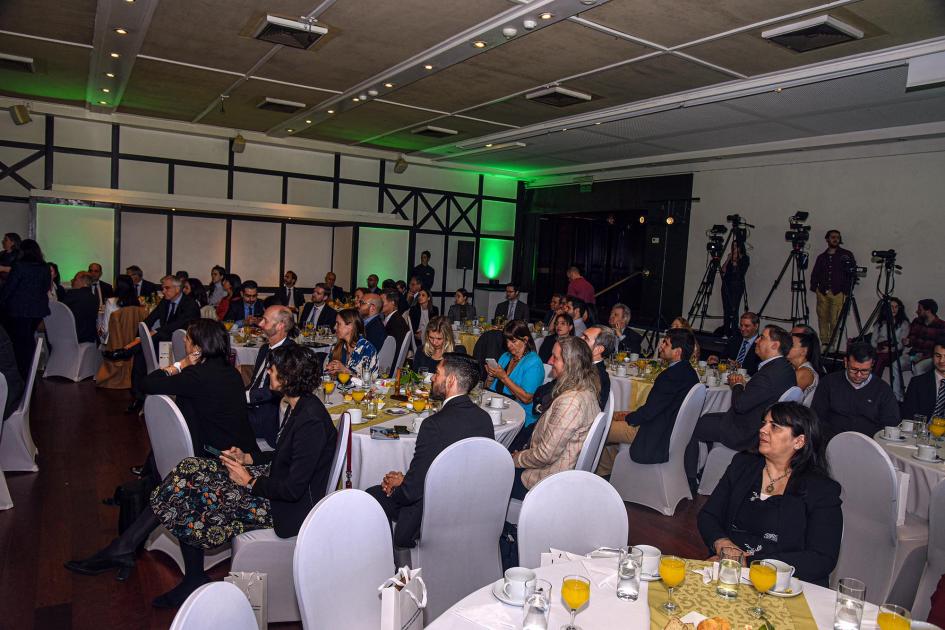 Participantes de la actividad Público en el Club de Golf; están sentados en mesas en las que hay desayouno
