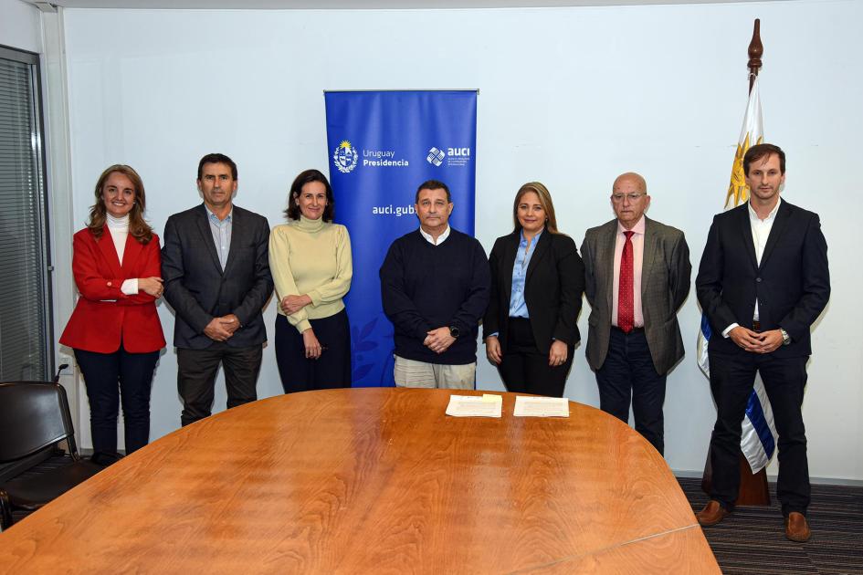 Foto grupal de las autoridades; en medio, banner de AUCI