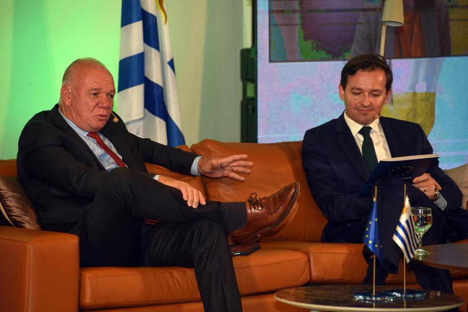 Walter Verri, sentado en un sillón, junto al moderador del panel, Damian Kaminiski