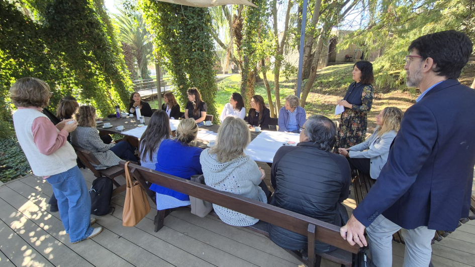 Personas dialogan, sentadas y de pie, en un espacio exterior