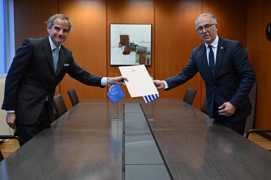 Director general del OIEA, Rafael M. Grossi, y embajador de Uruguay en Austria, Juan Carlos Ojeda Director general del OIEA y embajador de Uruguay en Austria se dan la mano a los lados de una mesa