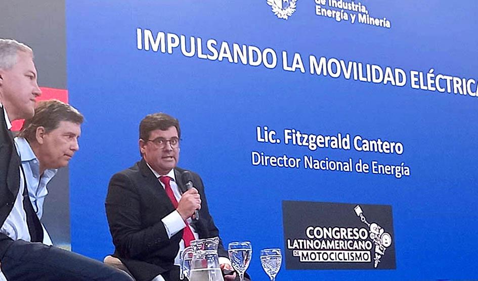 Director nacional de Energía, Fitzgerald Cantero Director nacional de Energía habla junto a dos hombres; detrás se ve el título de su charla