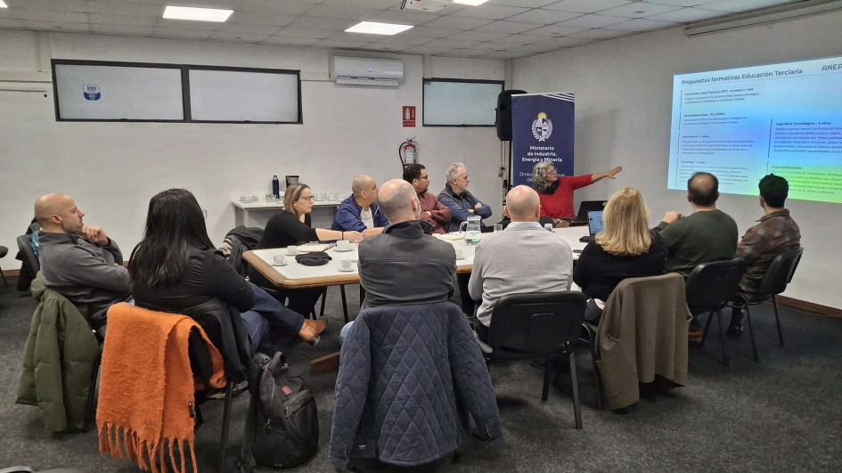 Reunión del Núcleo Productivo Forestal Maderero y UTU Personas sentadas en círculo alrededor de mesa; a la derecha, una pantalla