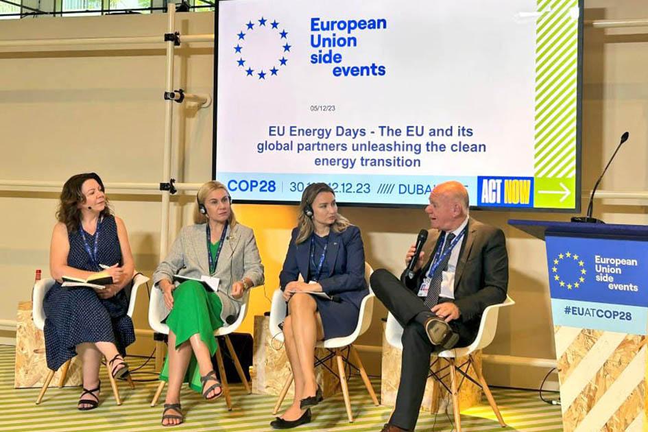 Verri expuso la transición energética uruguaya en un evento sobre la Unión Europea y sus socios Verri habla, sentado, junto a tres mujeres; detrás hay una pantalla; al lado, un atril