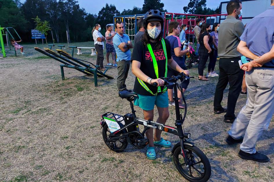 Bicicleta eléctrica adquirida en Kiyú Joven mujer sobre una bicicleta eléctrica; se ven otras personas en una placita