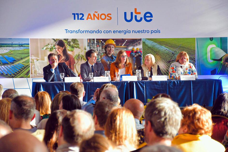 UTE celebró su aniversario con la presencia de la ministra Elisa Facio Al fondo, mesa de autoridades; detrás, banner institucional; más cerca, público, de espaldas