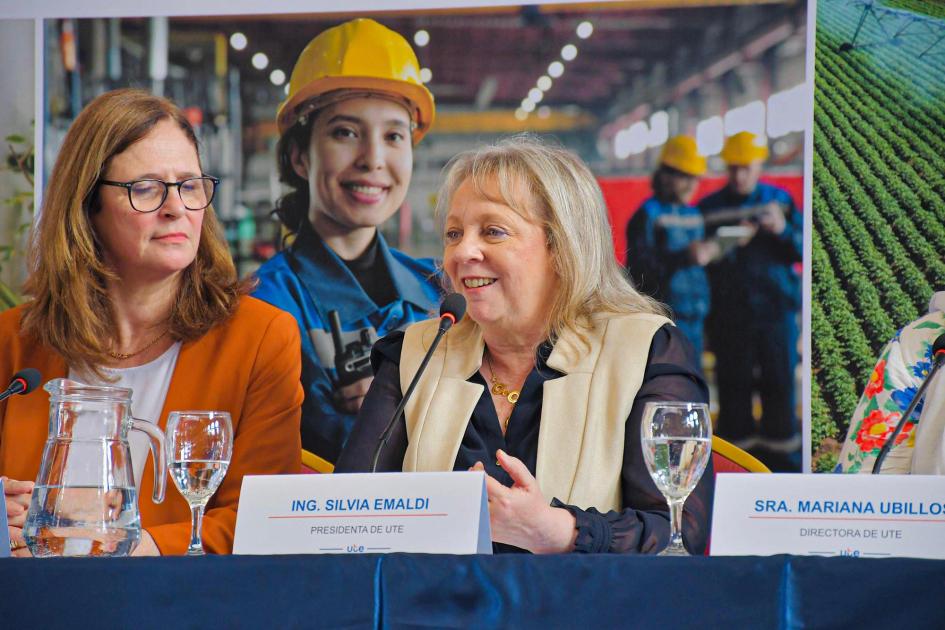 Presidenta de UTE, Silvia Emaldi Presidenta de UTE habla junto a la ministra Facio; detrás, banner institucional