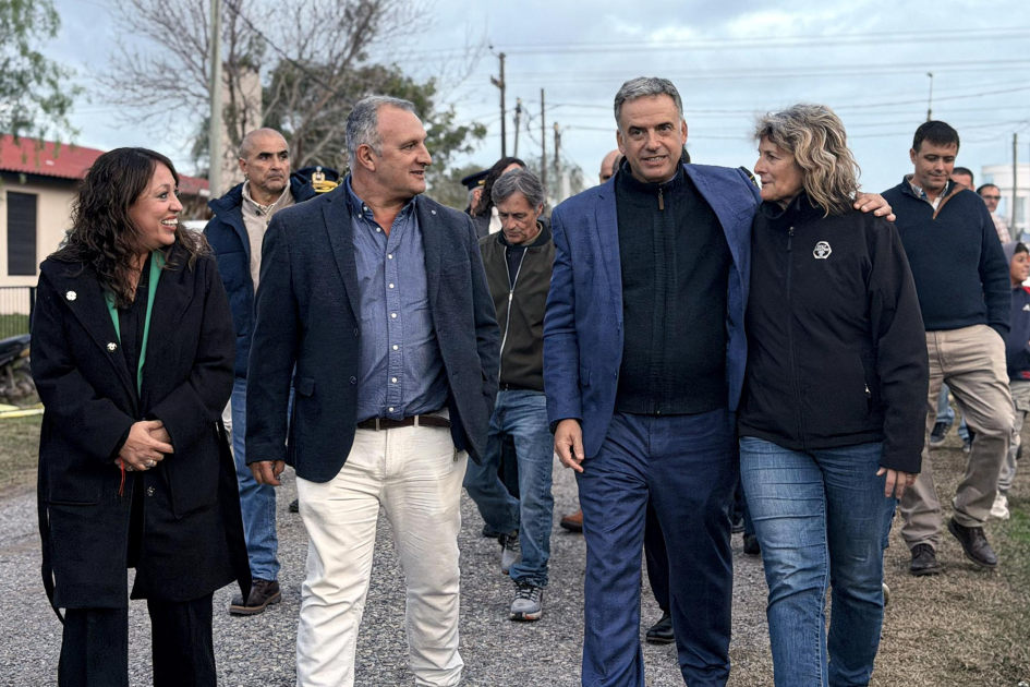 Inauguración de luminarias en la cancha de baby fútbol de José Pedro Varela Cardona, Orsi, Ximénez y una mujer caminan