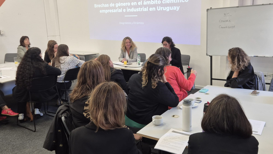 Personas trabajan en grupos, alrededor de mesas