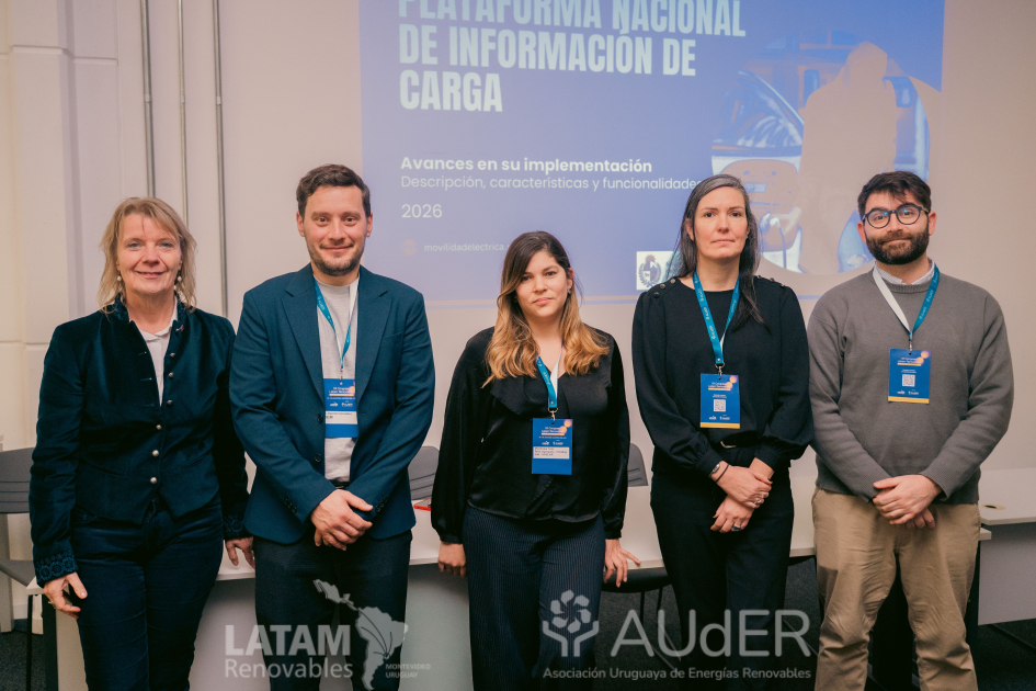 Participantes del encuentro sobre movilidad eléctrica en Uruguay, de pie; detrás, pantalla