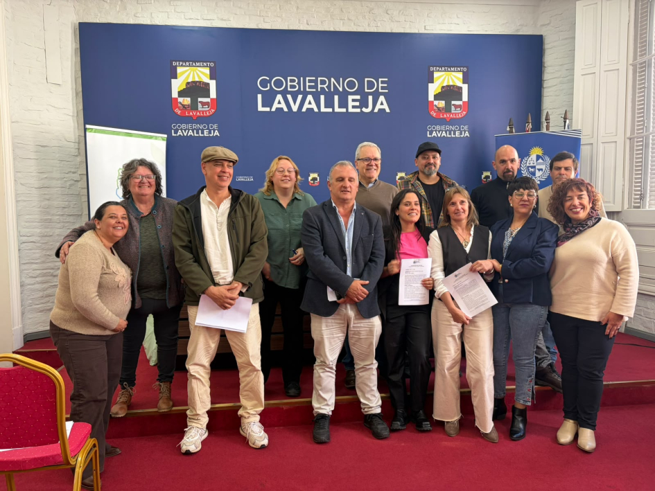Personas de pie; detrás, banner de la Intendencia de Lavalleja