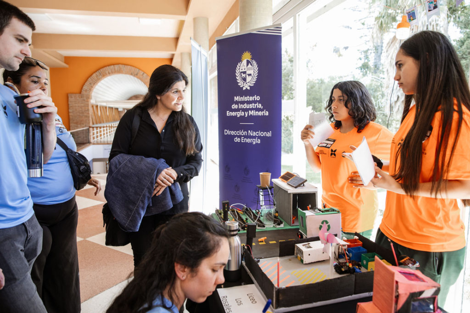 Estudiantes explicándole a la directora nacional de Energía sobre lo trabajado en la muestra