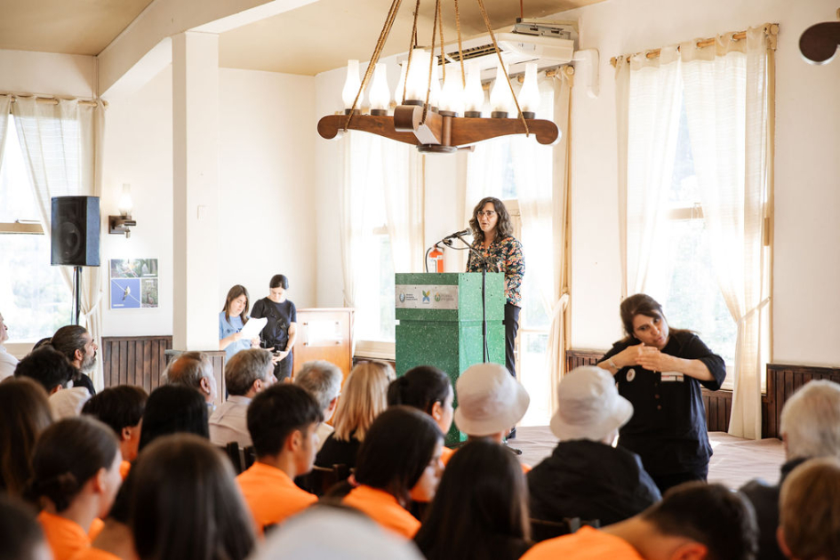 Cabrera habla a las y los estudiantes desde un atril