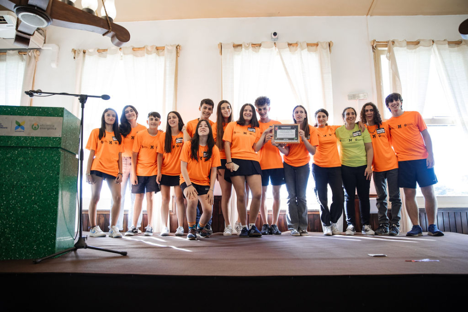 Estudiantes y docentes en escenario, con su reconocimiento.