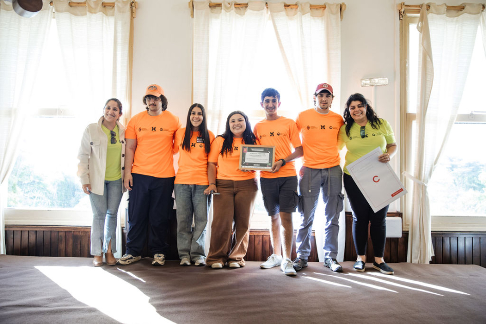 Estudiantes y docentes en escenario, con su reconocimiento.