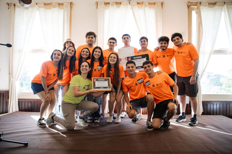 Estudiantes y docentes en escenario, con su reconocimiento.